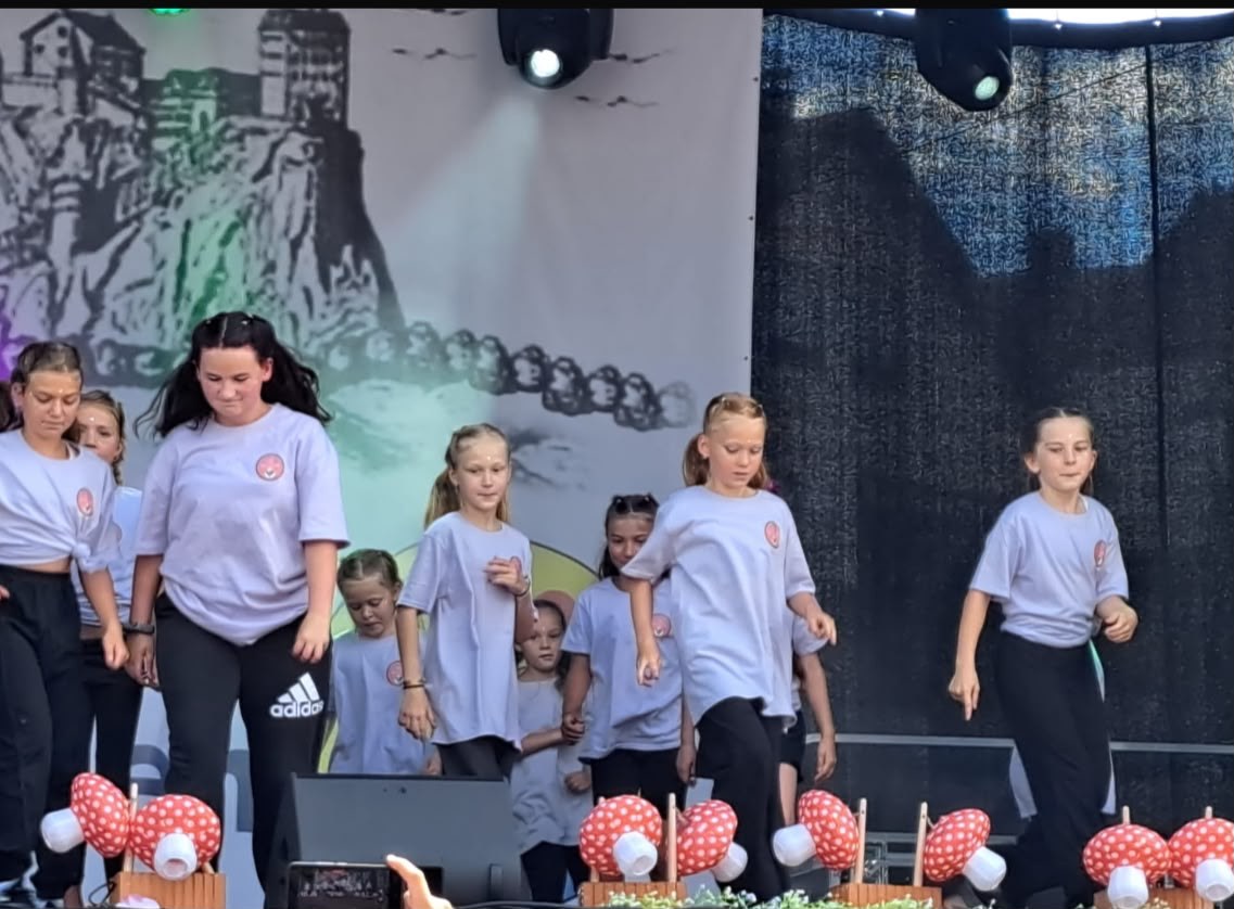 Die Diamonds tanzen auf einer Bühne in grauen T-Shirts