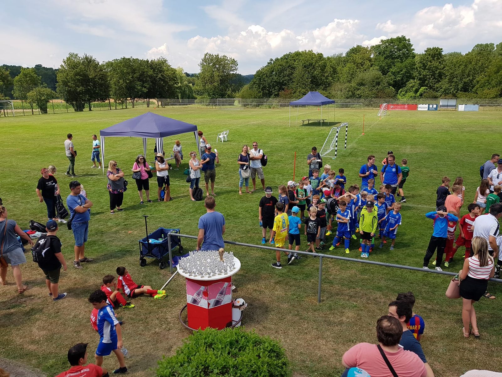 Jugendturnier auf dem Sportplatz mit Pokaltisch und Zuschauern